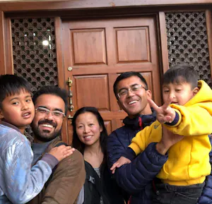 A group of people posing for a photo in front of a door.