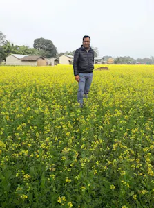 A man standing in a field of yellow flowers.