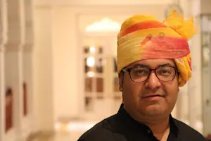 A man in a yellow turban standing in a hallway.