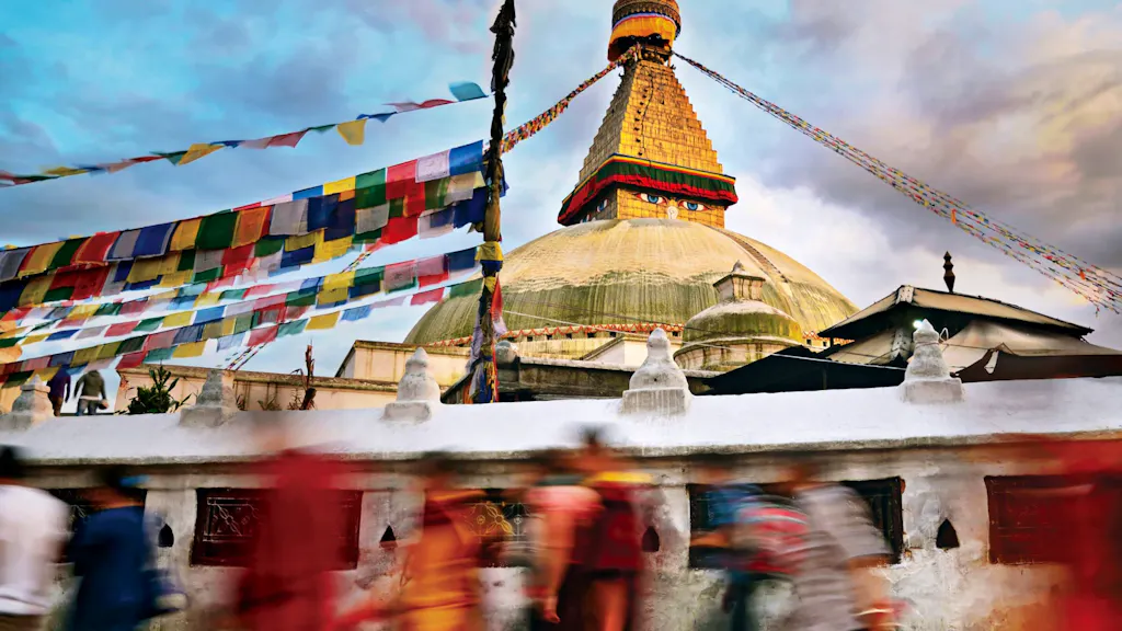 A group of people walking past a pagoda in kathmandu.