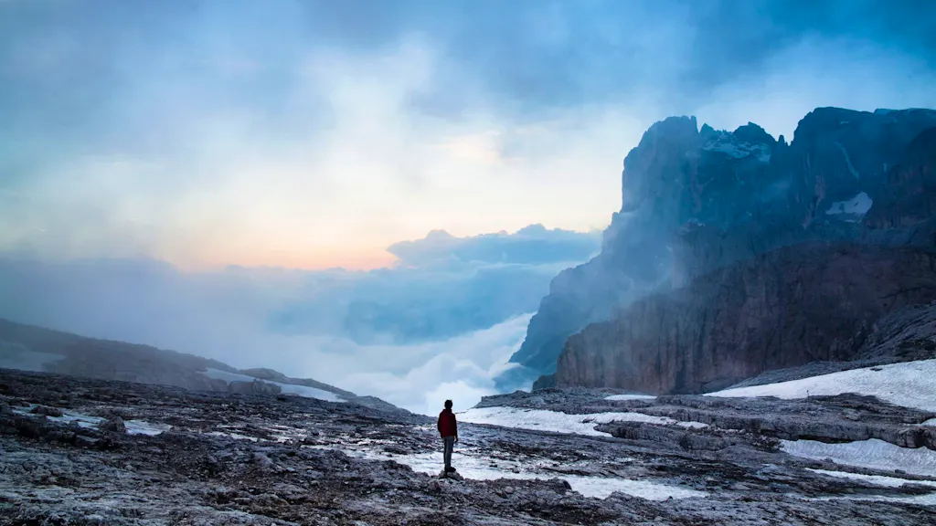 A person standing on top of a mountain in the snow.
