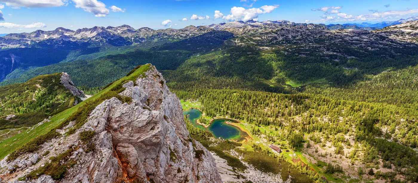An aerial view of a mountain with a lake in the background, perfect for adventure travel enthusiasts in Julian Alps in Slovenia