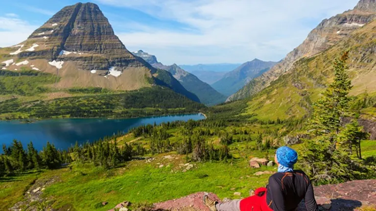 A woman enjoys the view of a lake in Glacier National Park, one of the best hikes.