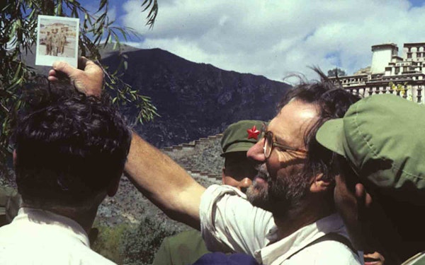 About us: A group of men capturing a majestic mountain in a photograph.