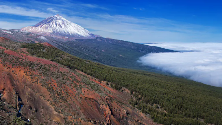 A mountain with clouds in the sky.