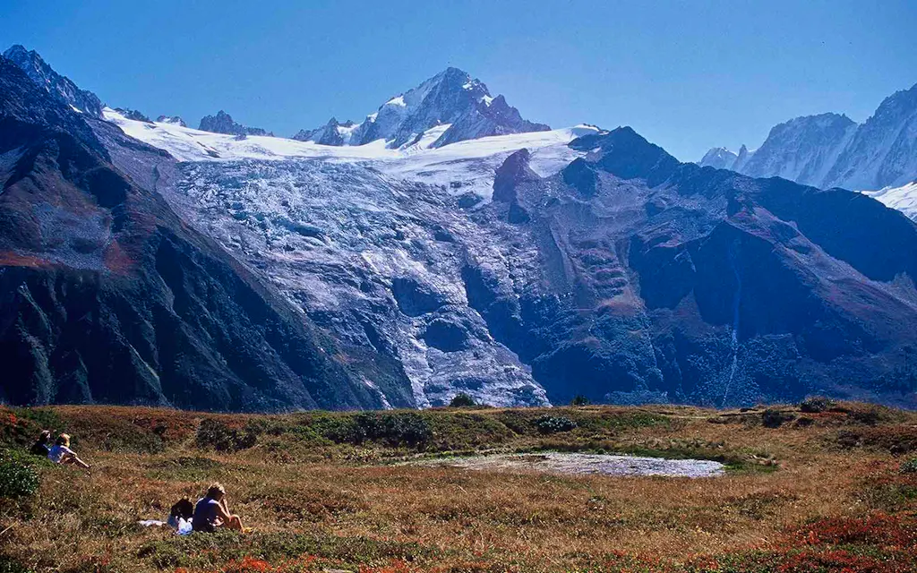 Hikers resting and taking in landscape views of the Alps Mountains in France.