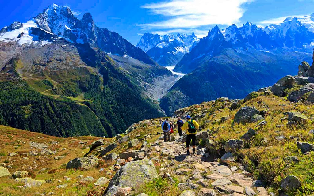 A group of people hiking up a rocky path in the mountains on Patagonia hiking tours.
