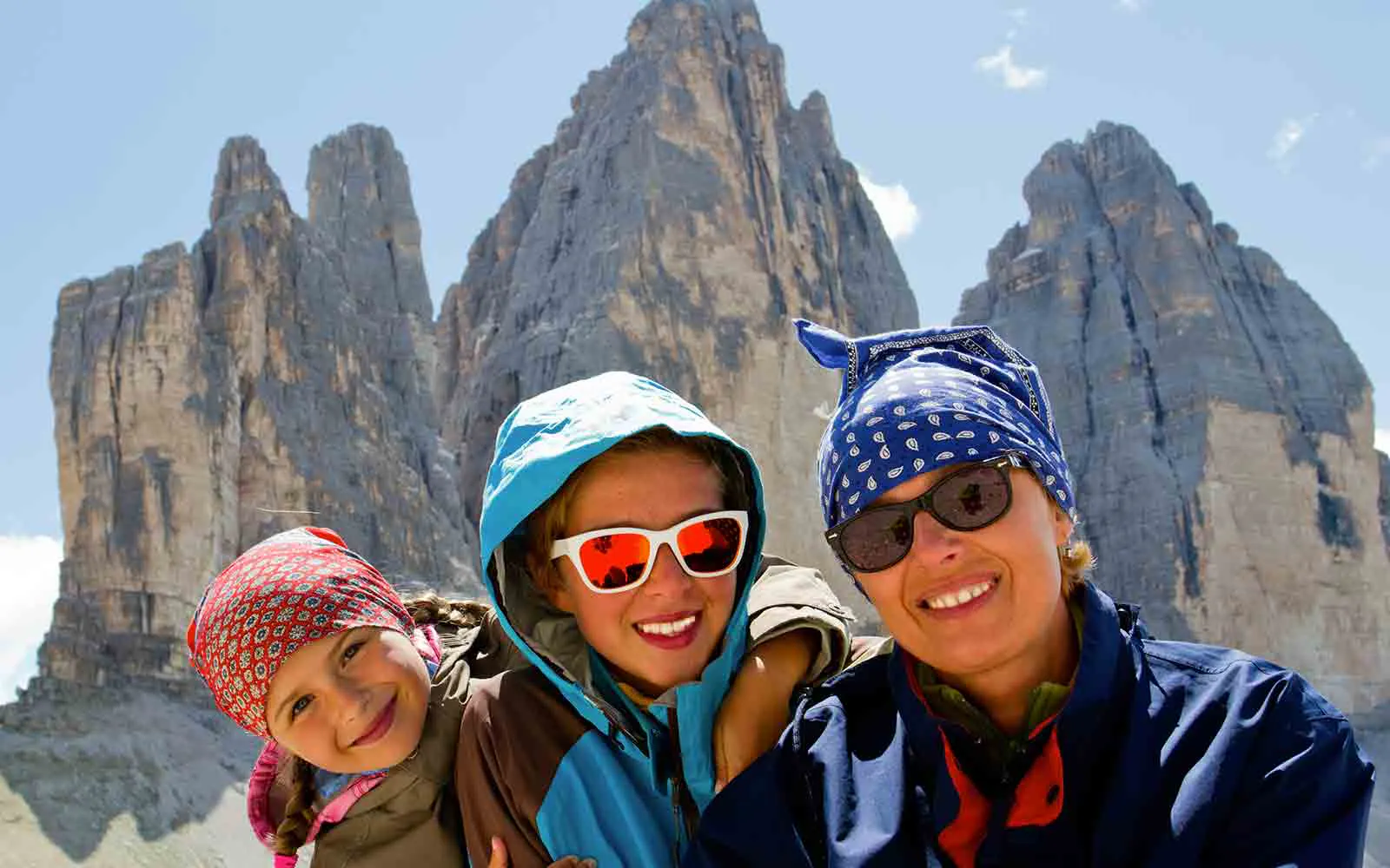 A group of people posing for a picture during hiking tours in front of a majestic mountain.