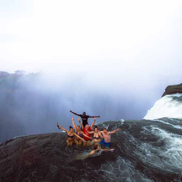 A group of people standing on top of a waterfall.