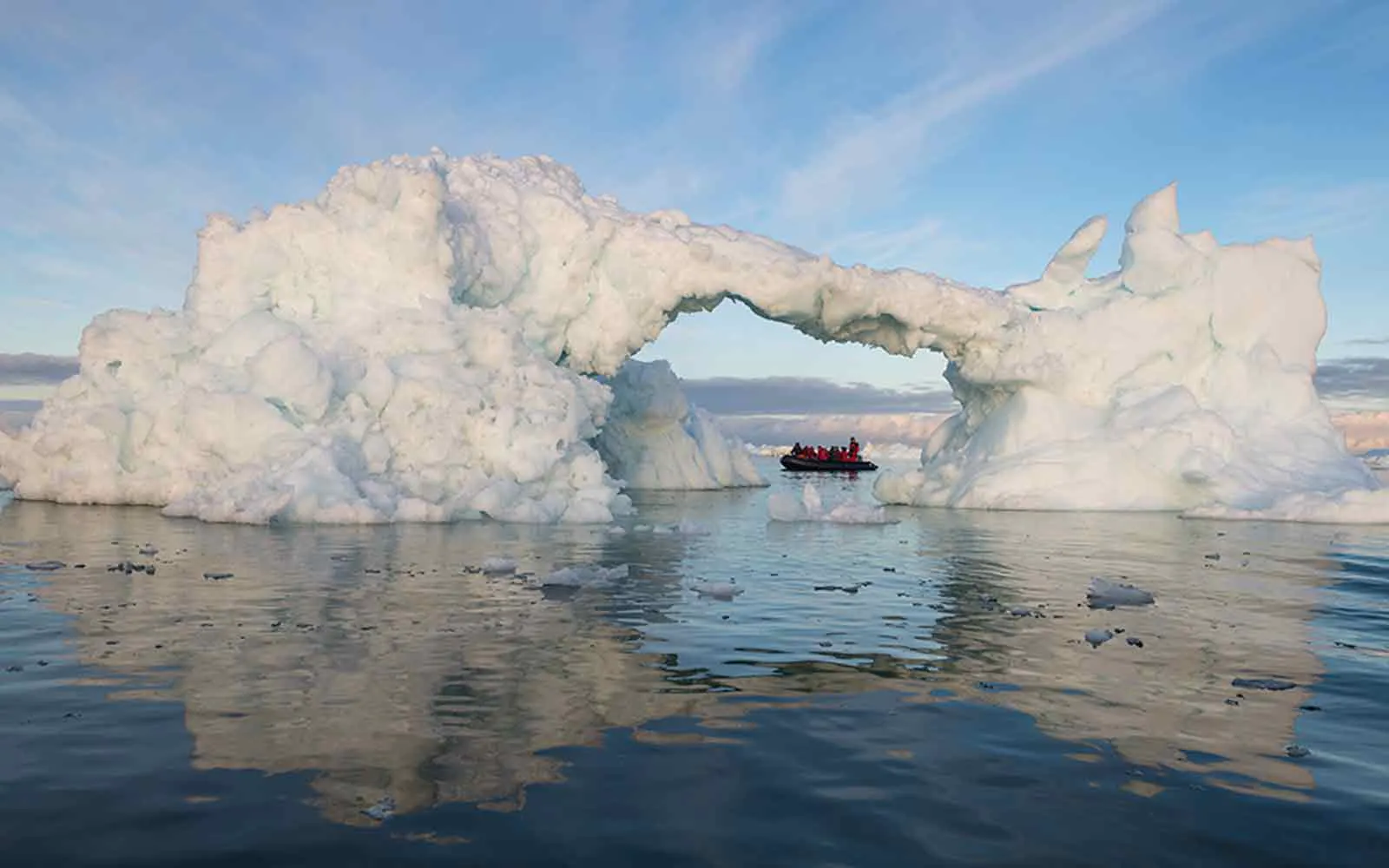 An iceberg in the water with a boat in it, offering an exciting adventure cruise experience.