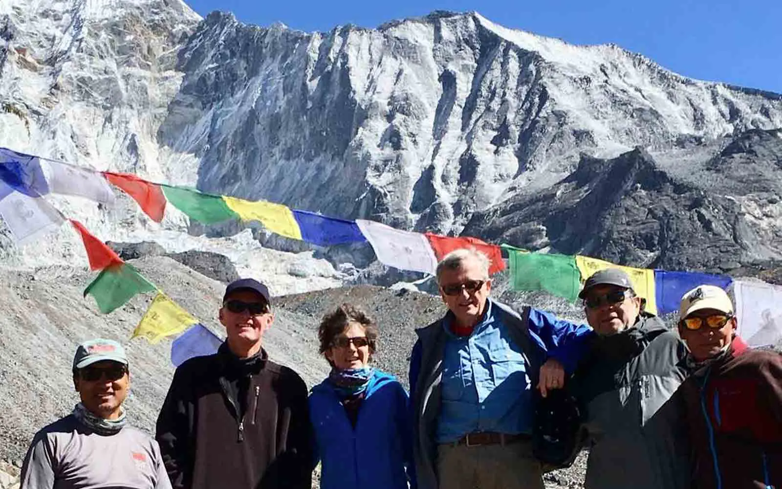 A group of people standing in front of a mountain during their Nepal Trekking Adventure.