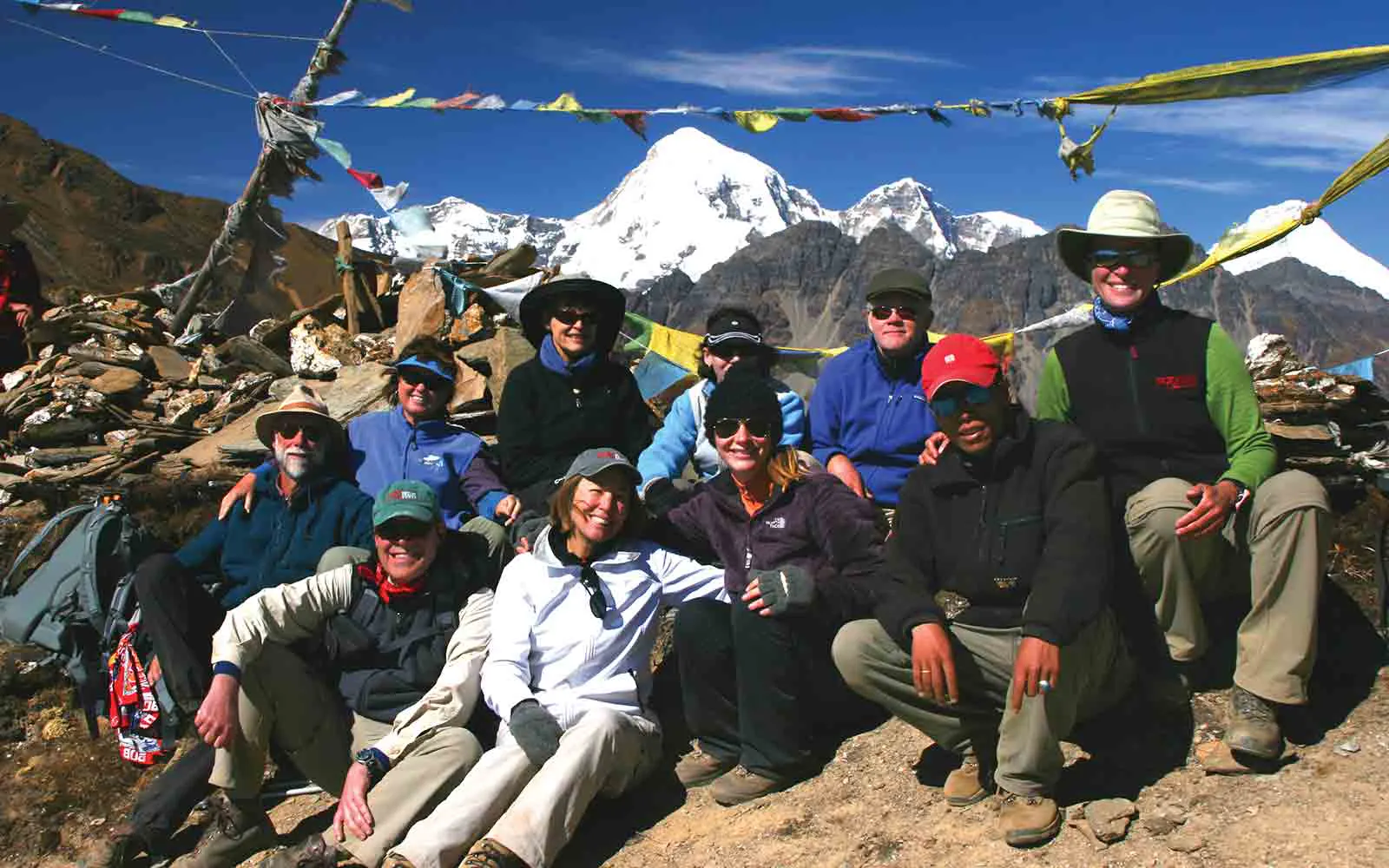 A group of people posing for a photo in front of mountains.