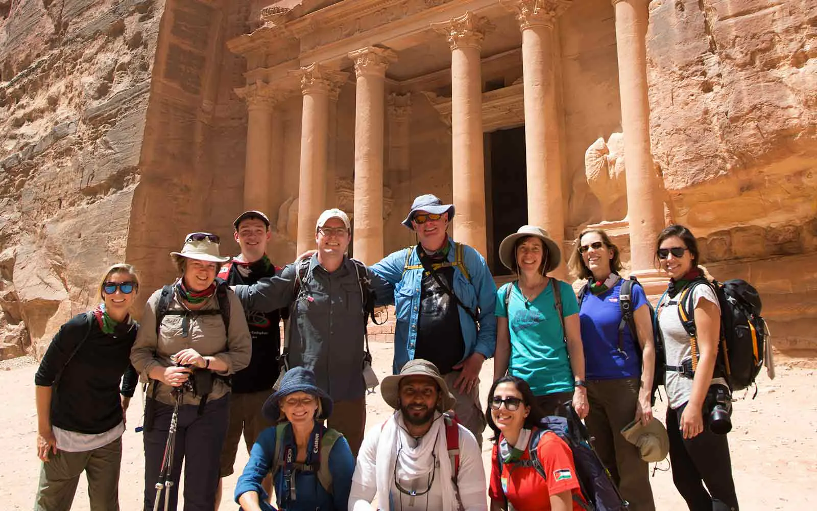 A group of people posing for a photo in front of the treasury.