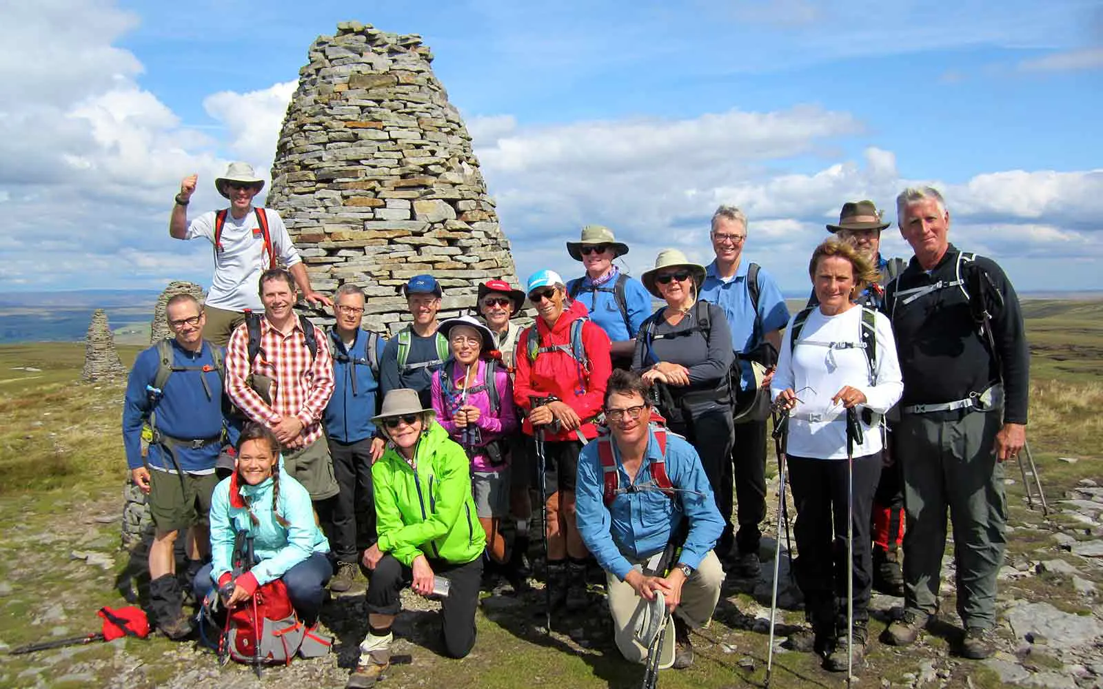 A group of people on an adventure tour in Europe posing for a photo in front of a stone structure.