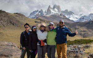 A group of people posing for a photo in front of a mountain during their active adventure in Patagonia.