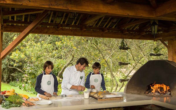 A group of people cooking in an outdoor kitchen.