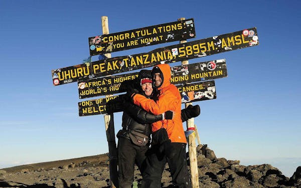 Two people hugging at the top of a mountain during an Africa Adventure Travel