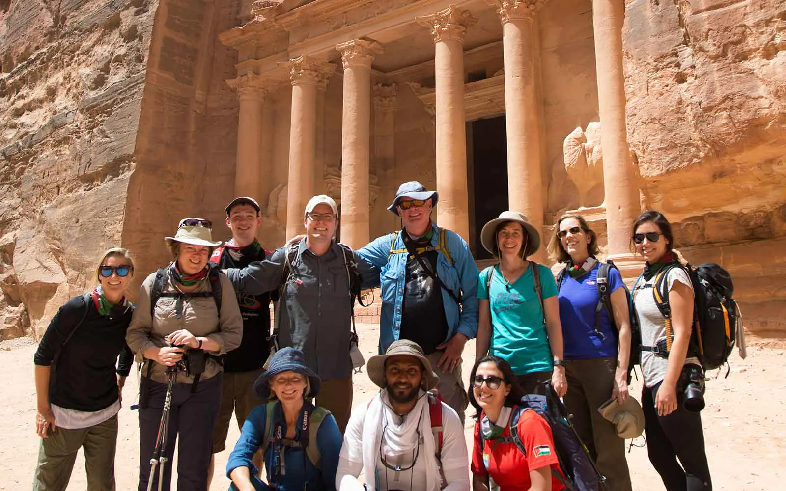 A group of people posing for a photo in front of the treasury.