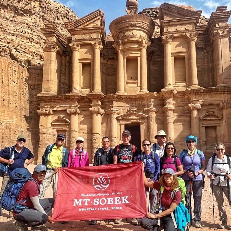 Adventure travel enthusiasts posing in front of a building in Jordan.