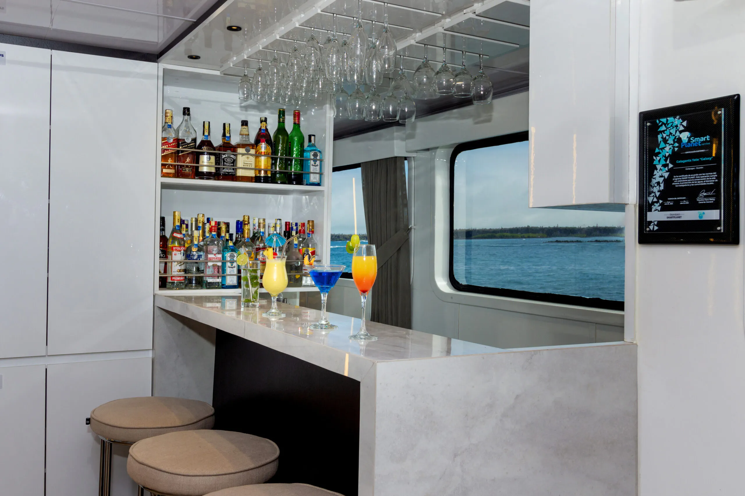 A bar with stools and a view of the water.