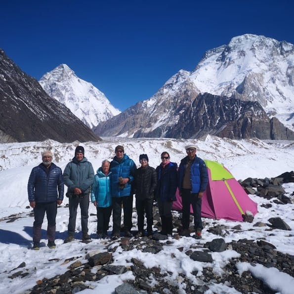 Adventure travel enthusiasts standing in front of a tent in the snow.