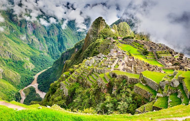 aerial view of Machu Picchu and ancient Incan trail paths and the Peruvian Andes