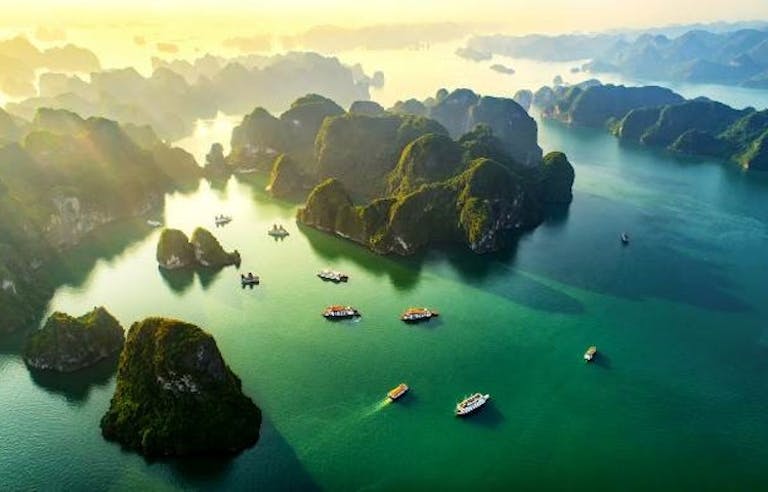 Ride a junk, a wooden Chinese sailing ship, in the beautiful Halong Bay islands in Southeast Asia
