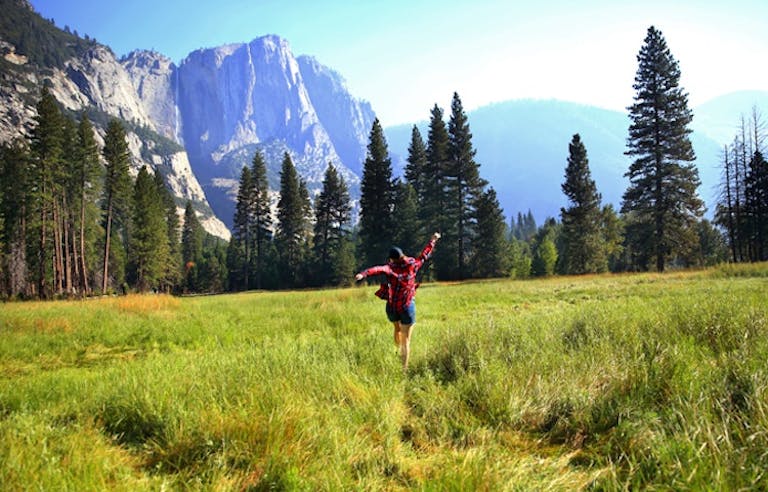 woman hiker joyfully trekking to the great Yosemite 
