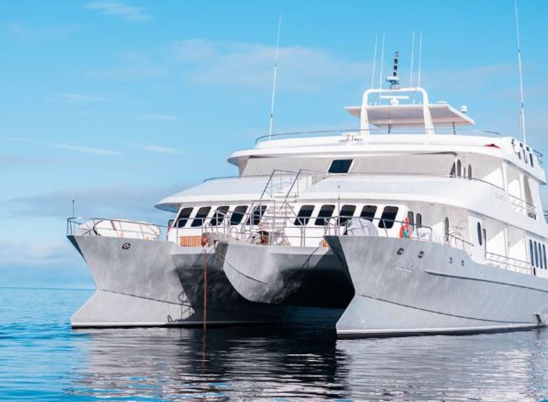 A luxurious white boat is floating in the Galapagos ocean.