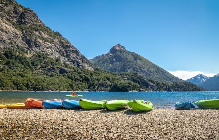 Kayaks sitting on shorelines of Patagonia coastal beach 