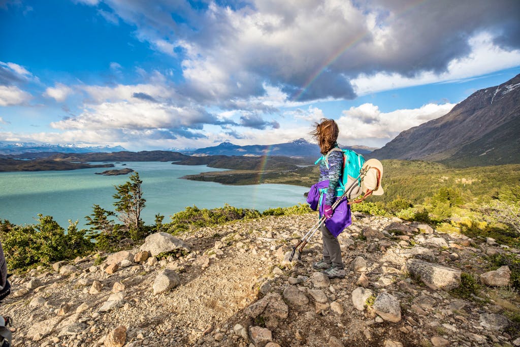 Solo hiker in hiking gear looking at the water in Patagonia