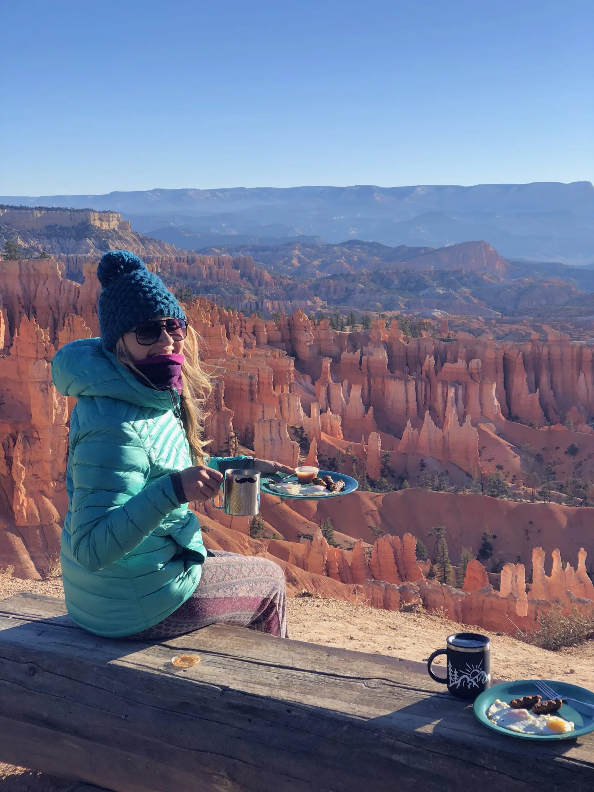 A woman sitting on a bench in bryce canyon.