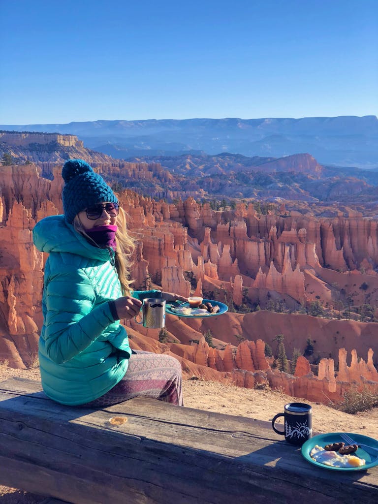Hiker enjoying a warm breakfast with a brilliant hoodoos view in Bryce Canyon's National Park