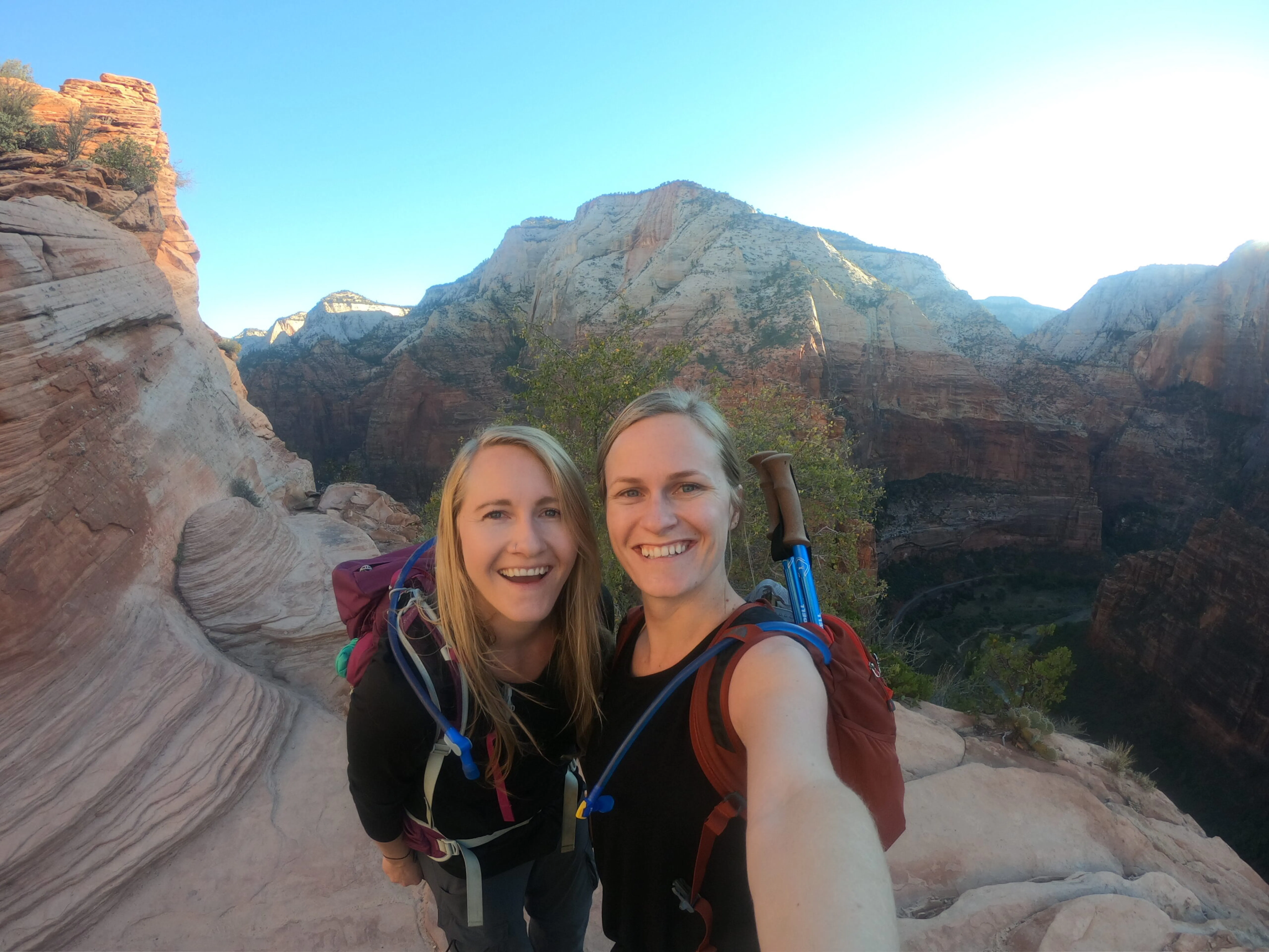 Two women taking a selfie on a rocky trail.