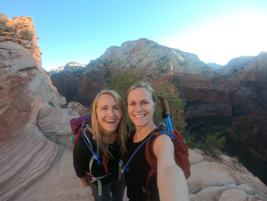 Two women taking a selfie on a rocky trail.