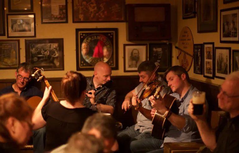 Musicians serenading tourists at a vibrant pub in Ireland