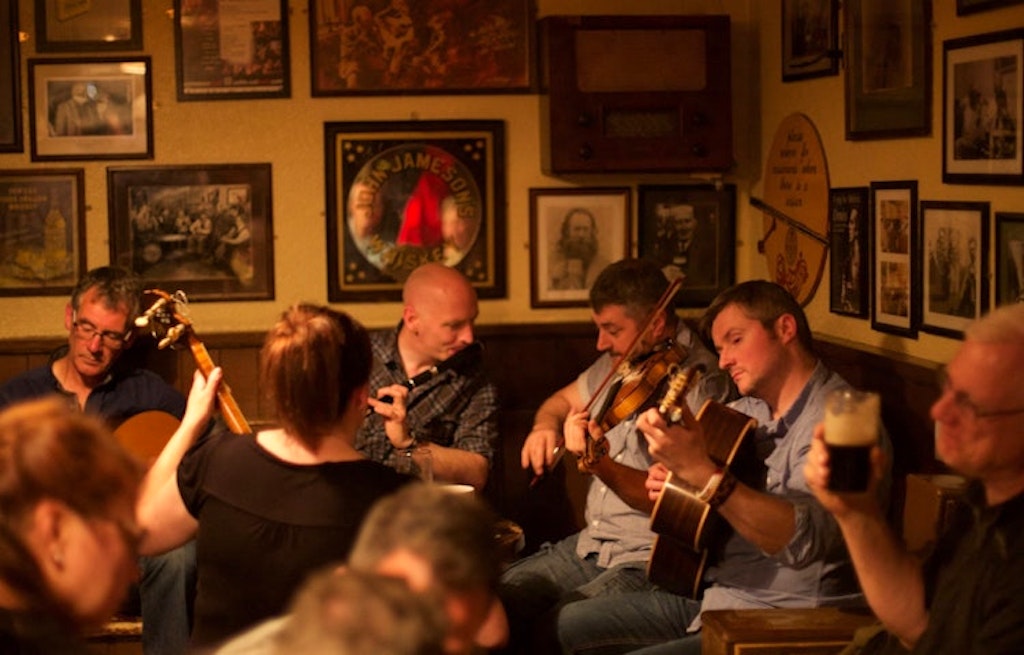 Musicians serenading tourists at a vibrant pub in Ireland 