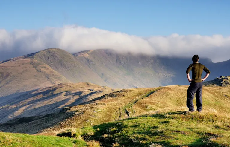 Hiker looking at mountainous trail in England during a guided tour