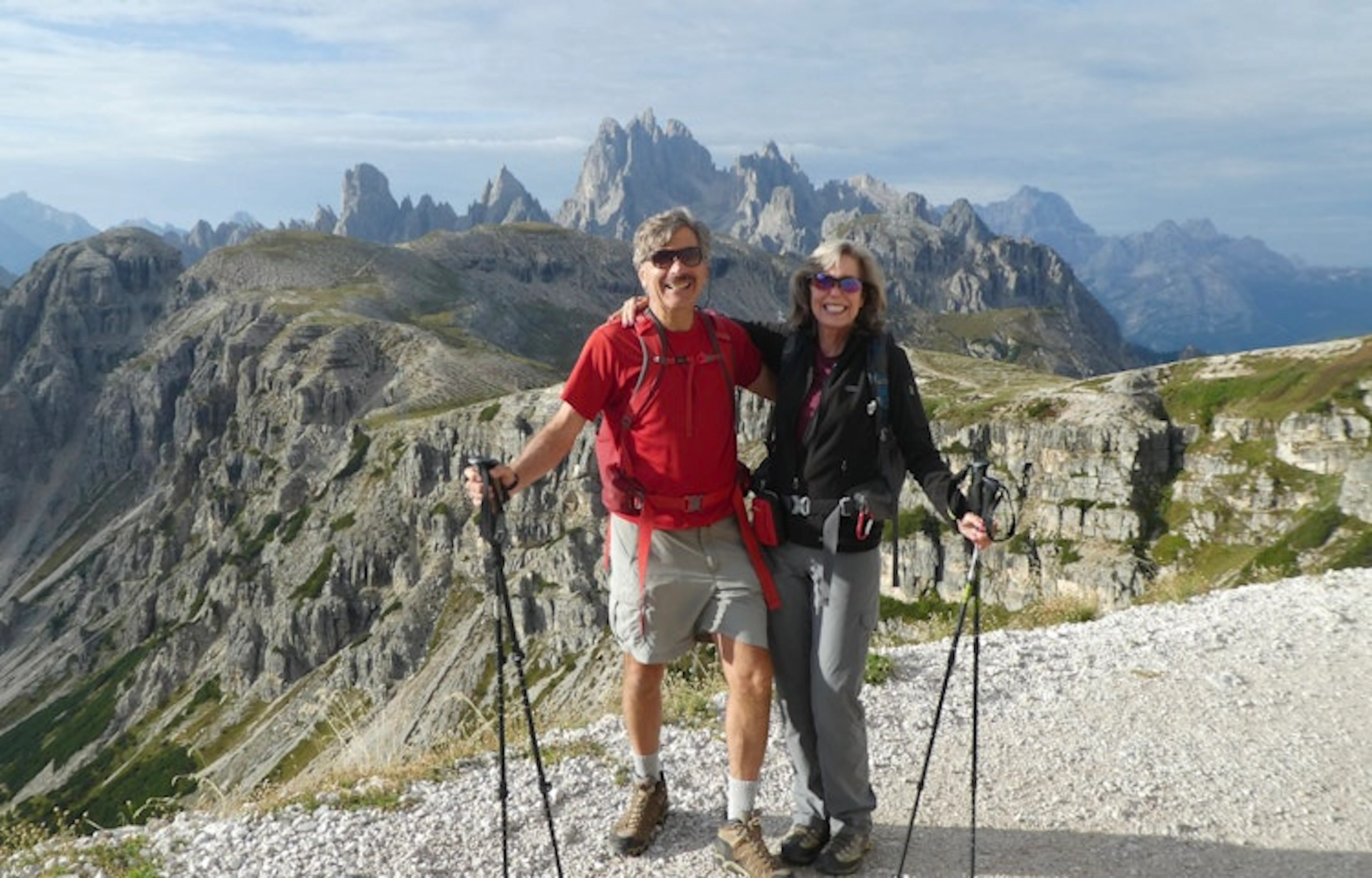Couple hiking on a rugged trail in the Dolomites, Italy