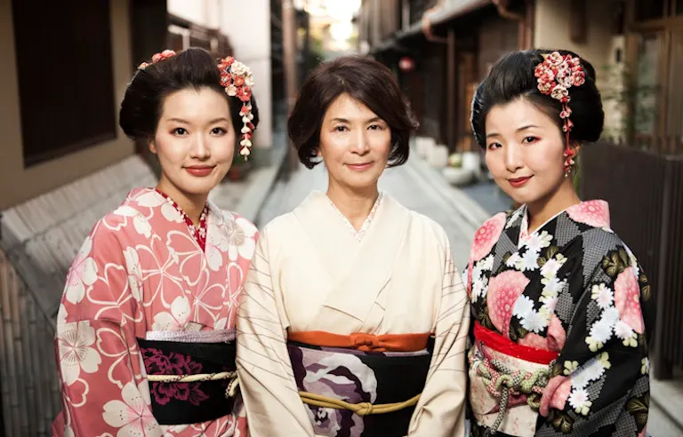 young and old geishas in Japan smiling