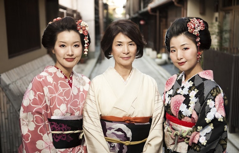 young and old geishas in Japan smiling