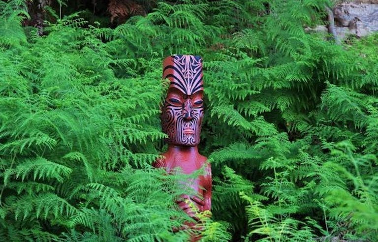 wooden idol in enchanting Whirinaki rainforest, one of the world's last prehistoric rainforests in New Zealand North Island in Europe