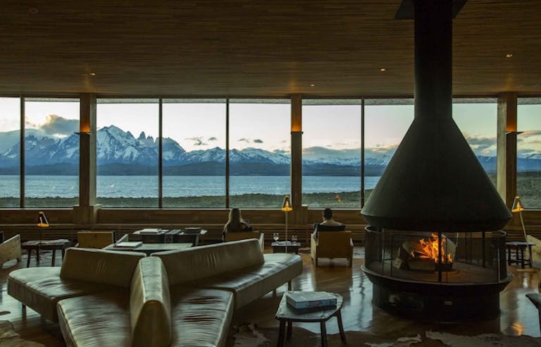A living room with a fireplace and a view of the mountains in Patagonia, near El Chalten