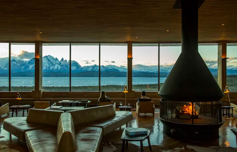 A living room with a fireplace and a view of the mountains in Patagonia, near El Chalten