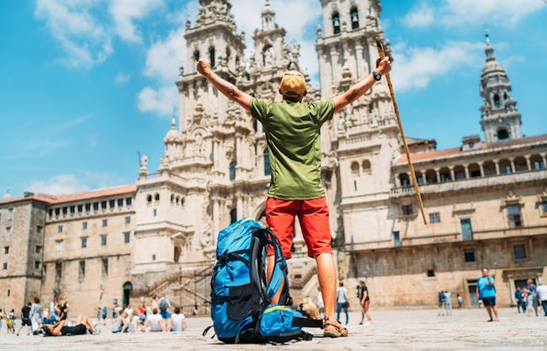 solo male traveler standing accomplished in front of the Santiago de Compostela in Spain, Europe