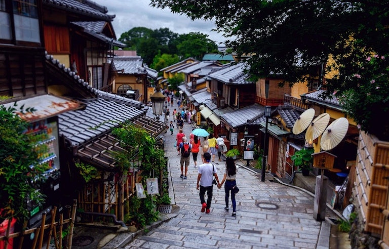 Tourists exploring Kyoto, or Old Japan with its temples, gardens, and treehouses
