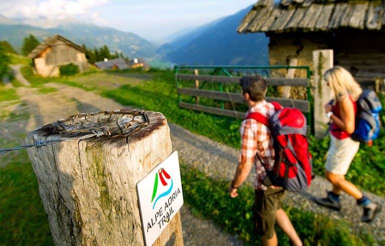 two hikers at the beginning of a hiking trail in Alpe Adria in Europe