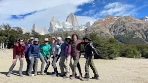A group of people posing for a photo in front of mountains during their Patagonia hike.