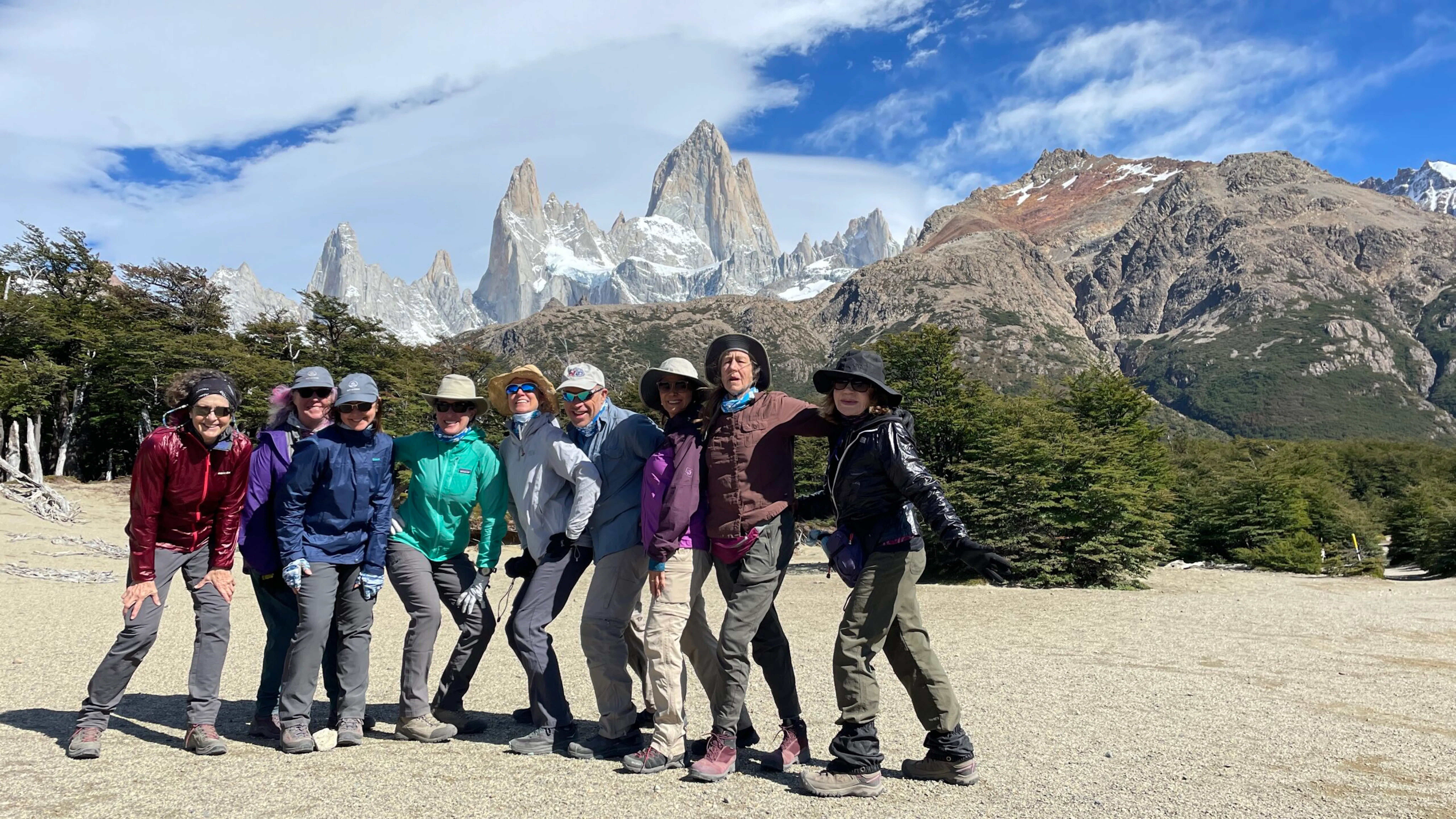 A group of people posing for a photo in front of mountains during their Patagonia hike.