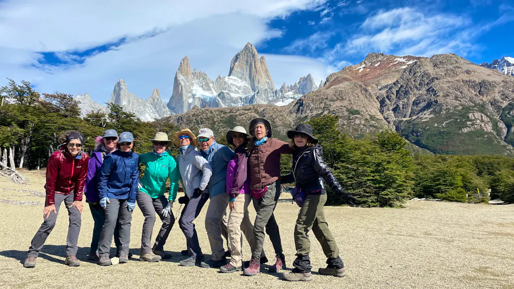 A group of people posing for a photo in front of mountains during their Patagonia hike.